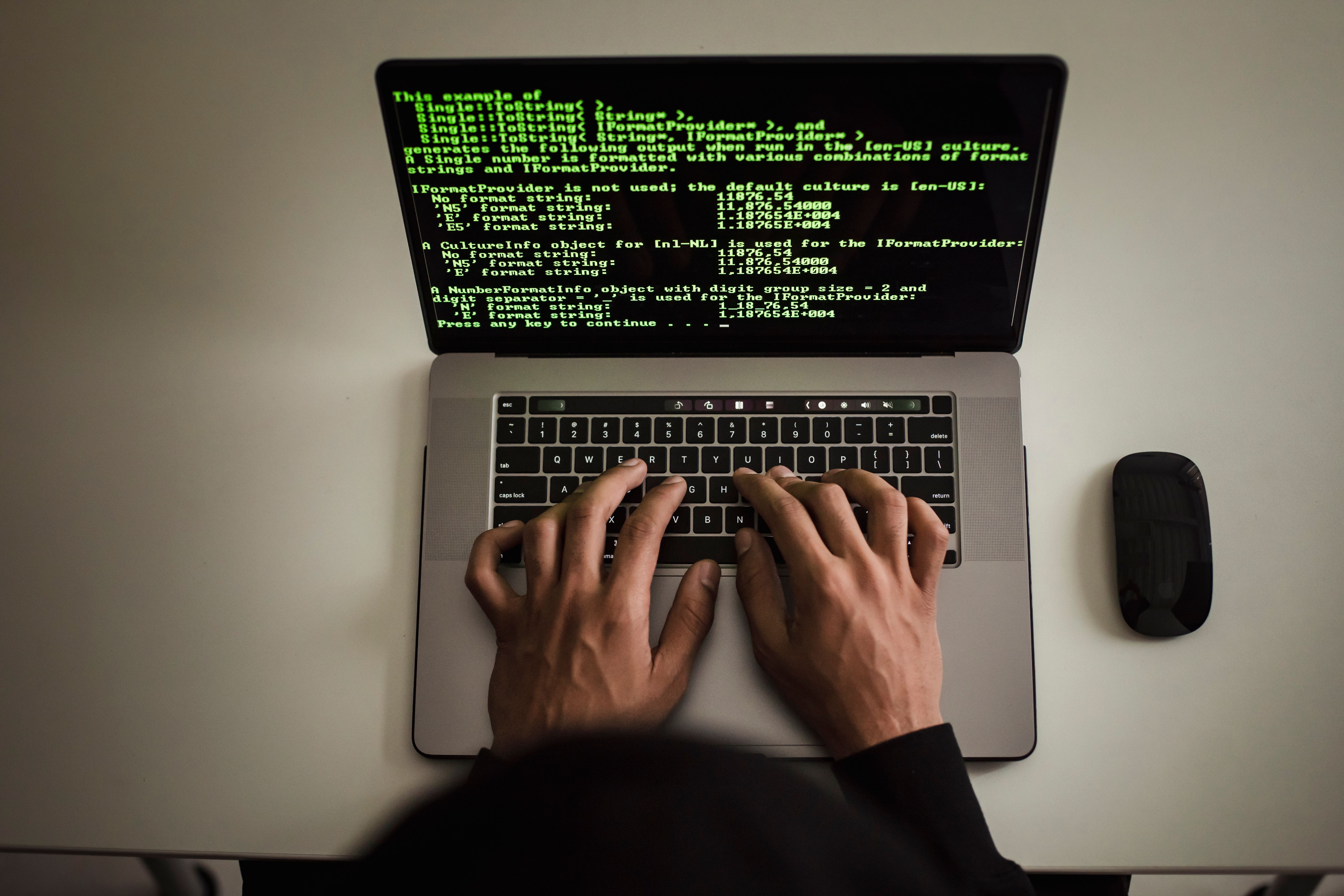 A developer writing code at a laptop